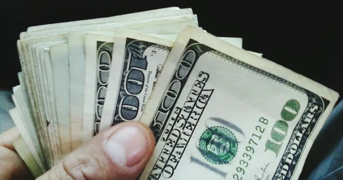 Hand holding US dollar bills